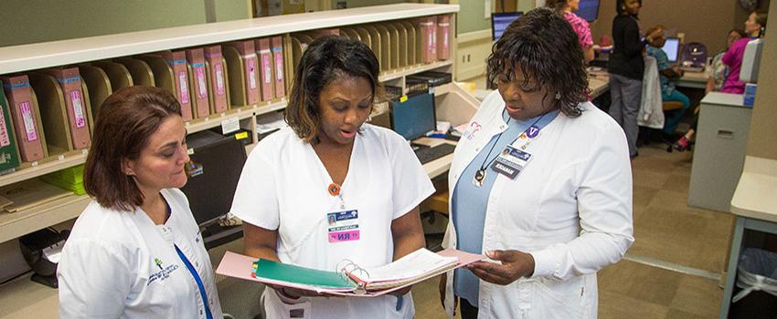 Nurses at work station reviewing chart